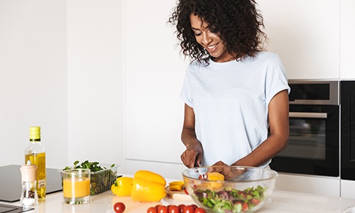 Woman smiling while preparing meal in kitchen