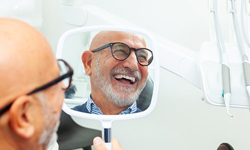 Man smiling at reflection in mirror