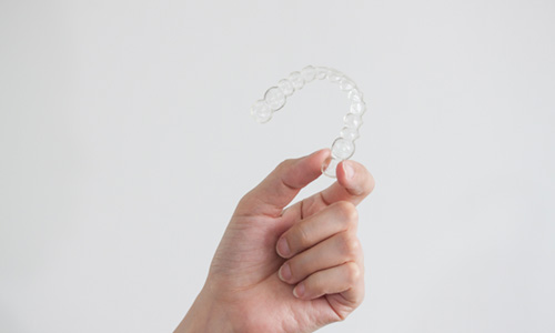 Closeup of patient holding clear aligner